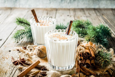 Zwei Gläser selbstgemachter Eggnog auf weihnachtlich geschmückten Tisch